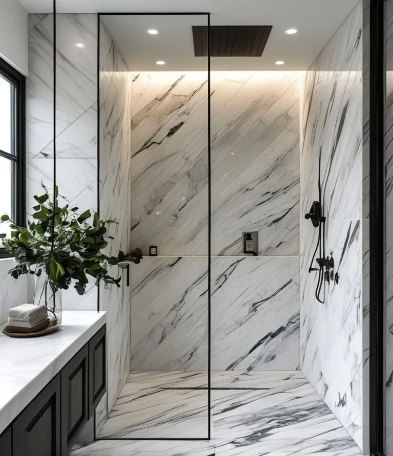 Walk-in shower with marble-look tile walls, black-framed glass partition and rain showerhead — bathroom design idea